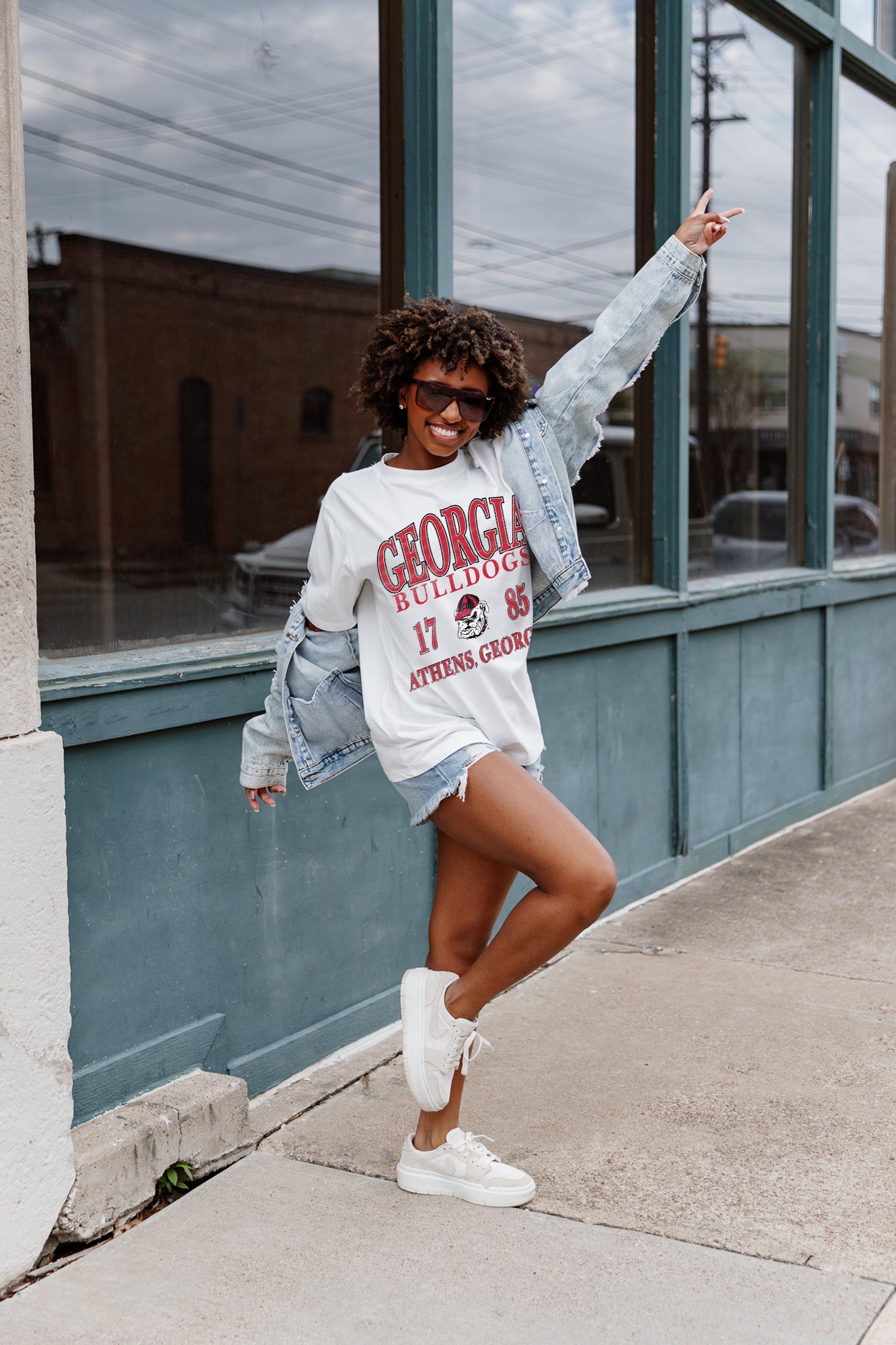 Ivory GEORGIA BULLDOGS Unity Oversized Tee - Seated Outdoor Lifestyle Shot with Wide-Leg Jeans | Gameday Couture - SOHO